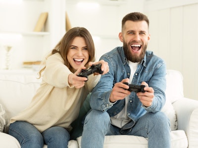Fans Of Xbox. Crazy Couple Enjoying Playing Videogame On Playstation, Resting At Home
