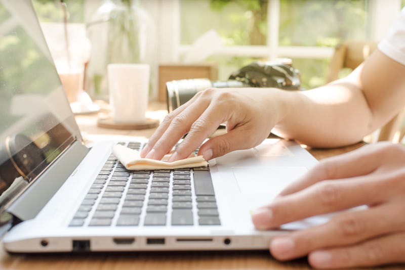 Close-up Of Man Hand Cleaning Laptop 