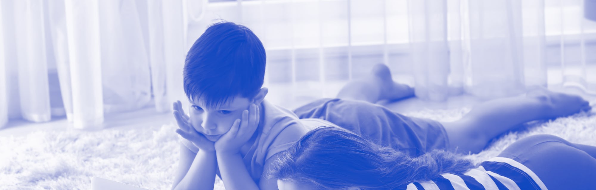 Cute little children with laptop watching cartoons at home