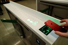 An Amazon employee demonstrates how to scan a code from a phone to be allowed to enter an Amazon Go ...