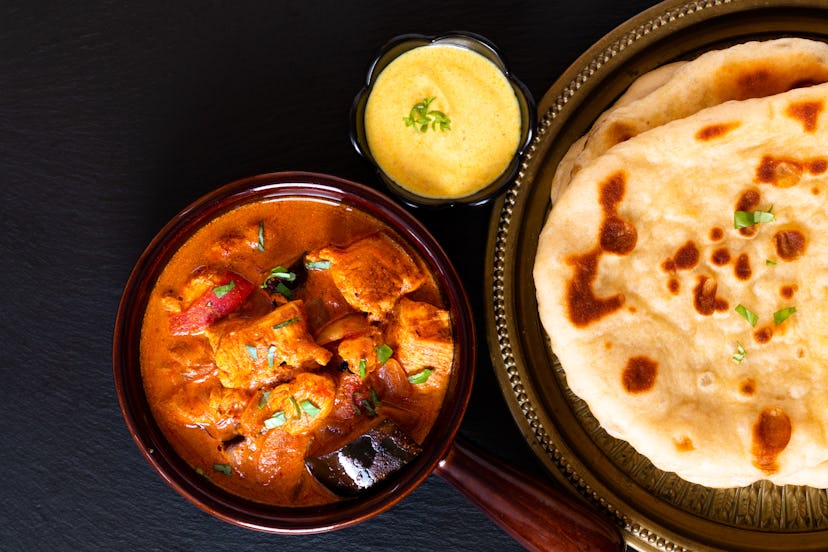 Food concept homemade Tandoori Chicken Masala curry with naan bread and yogurt dipping sauce with co...