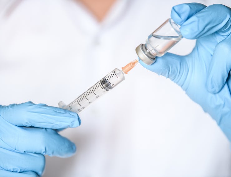 Doctor, nurse or scientist hand in blue nitrile gloves holding flu, measles, coronavirus (COVID-19) ...