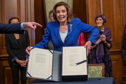 Democratic Speaker of the House Nancy Pelosi reacts after she enrolled the Coronavirus Aid, Relief, ...