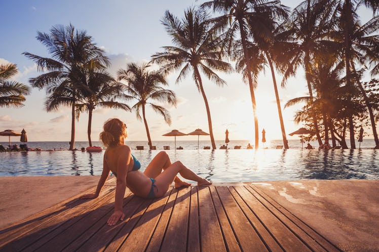 tropical getaway retreat in luxury beach hotel, luxury travel, woman relaxing near swimming pool at ...