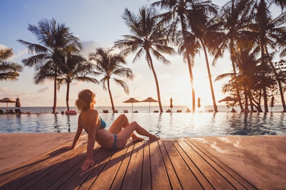 tropical getaway retreat in luxury beach hotel, luxury travel, woman relaxing near swimming pool at ...