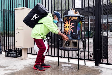 A homeless man washes his hands before receiving a bag of food from the Los Angeles Community Action...