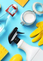 Flat lay composition with vinegar and cleaning supplies on color background