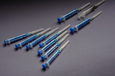 Syringe shape in the shape of a bird's wedge. Syringes on a gray background. Ten different used syri...
