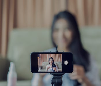 Young Asian cute artist woman beauty vlogger or blogger doing a cosmetic makeup tutorial vlog with b...