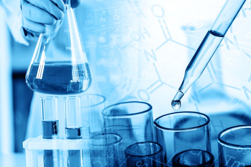 hand of scientist holding flask with lab glassware and test tubes in chemical laboratory background,...