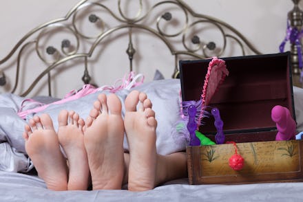 sexy couple lying in bed. use sex toys.
