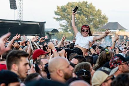 Benjamin Burnley. A festivalgoer crowd surfs as Breaking Benjamin performs during Louder Than Life a...