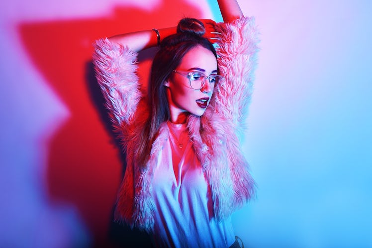 Fashion portrait of young elegant girl in glasses. Colored background, studio shot. Beautiful brunet...