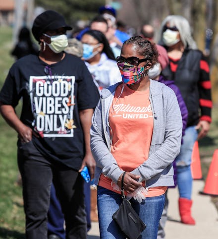 Voters wait in line to mark their ballots for the Wisconsin presidential primary election at Marshal...