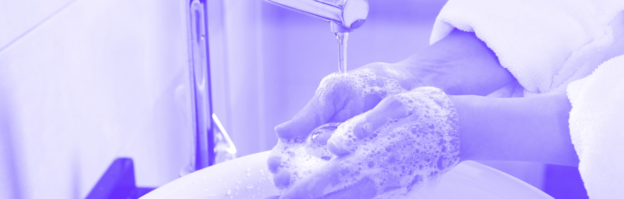 Woman washing hands with soap over sink in bathroom, closeup