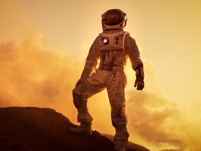Silhouette of the Astronaut Standing on the Rocky Mountain of the Alien Red Planet/ Mars. First Mann...