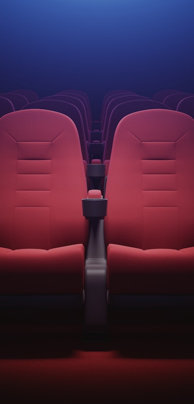 Interior of empty cinema with rows of red seats with cup holders and popcorn. Concept of entertainme...