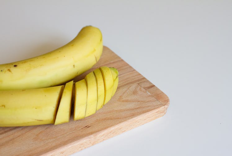 ripe yellow banana on a wooden Board on a white background. there are two bananas on the table. the ...