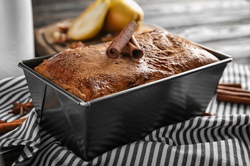 Baking pan with delicious cinnamon cake on table