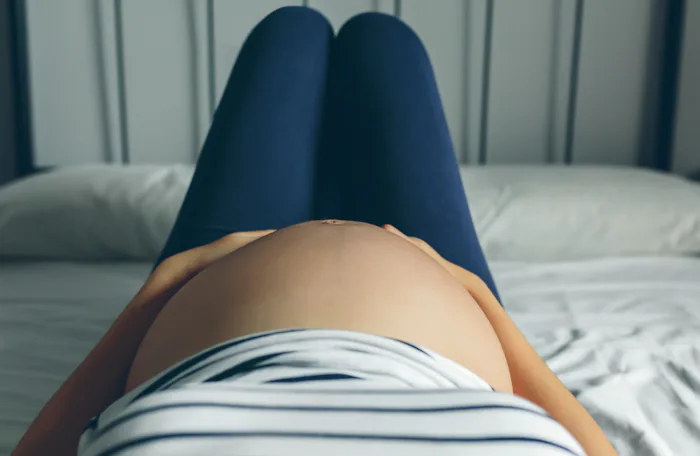 Pregnant woman lying in bed