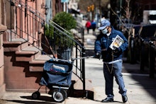 United States Postal worker makes a delivery with gloves and a mask in Philadelphia, . The U.S. Post...