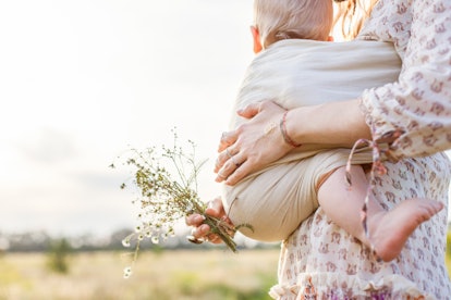 mother holding baby in baby carrrier