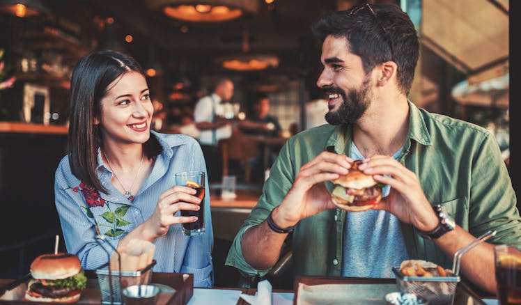 Happy loving couple enjoying breakfast in a cafe. Love, dating, food, lifestyle concept