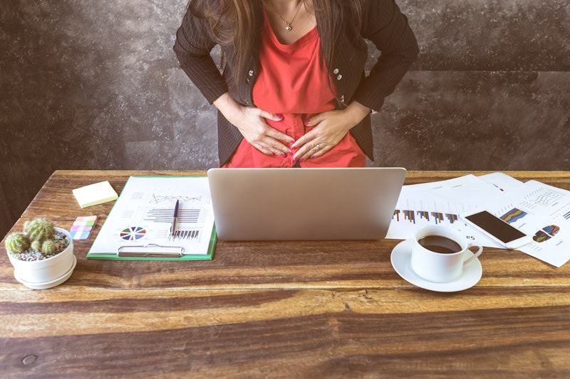close up of  young business woman having stomach ache or Chronic gastritis, ulcer,in office, Abdomen...