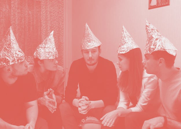Group of people with foil on their heads discussing conspiracy theories. Friends with foil on their ...