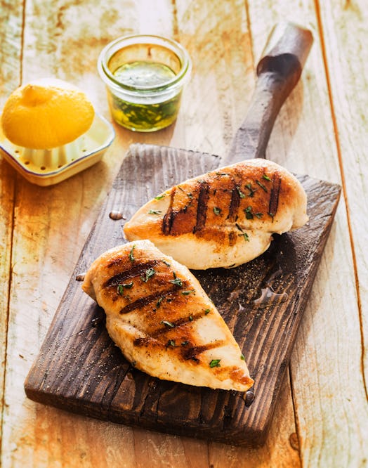 Healthy grilled chicken breasts marinated with lemon and olive oil and cooked on a summer BBQ served...