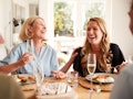 A happy and laughing mother and daughter enjoy brunch together at home. 
