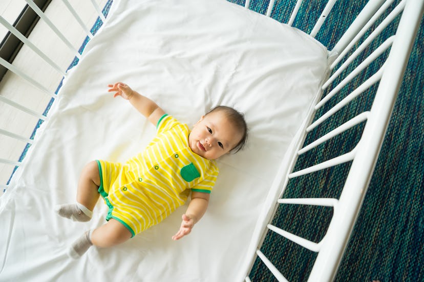 6 month old baby lying down in crib