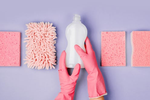 Detergents and cleaning accessories in pink color. Cleaning service concept. Flat lay, Top view.