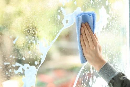 Woman cleaning window at home