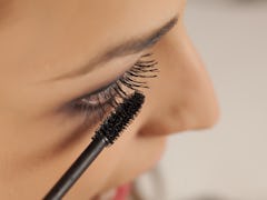 young woman applied mascara to her lashes