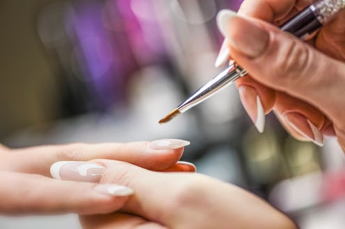Manicure nail paint with thin brush on colour background,Nails artist polish, modelation gel