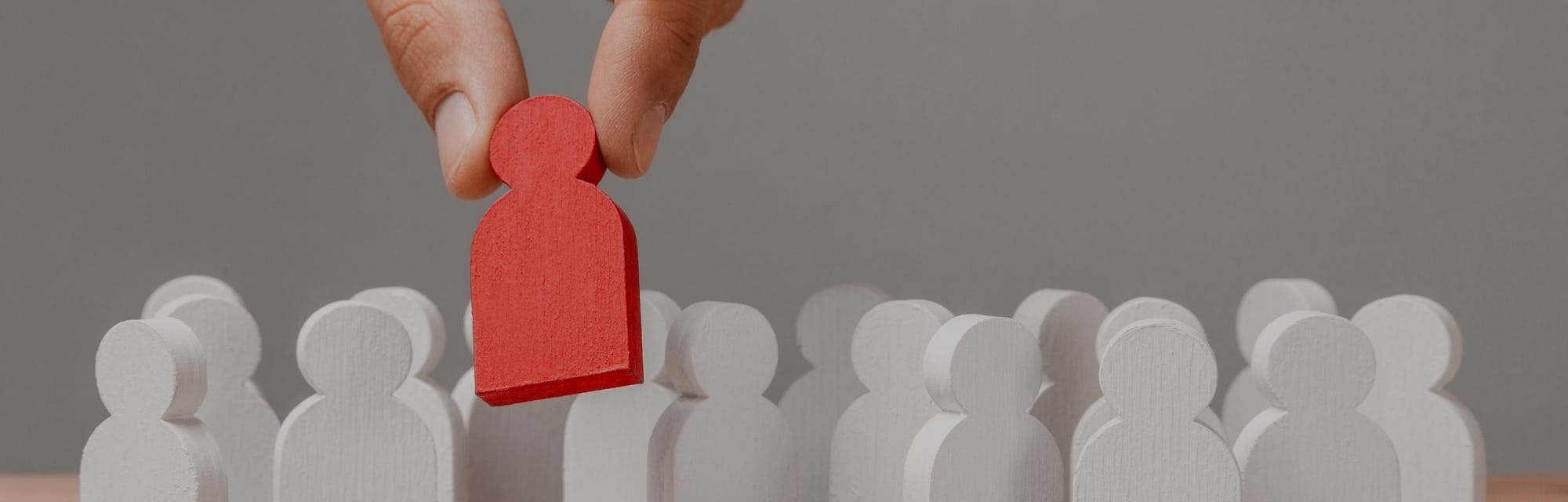 Choice of an employee leader from the crowd. Man holds an employee in his hand.