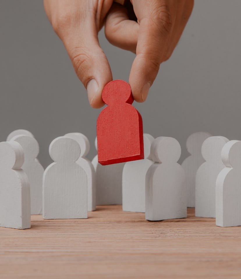 Choice of an employee leader from the crowd. Man holds an employee in his hand.