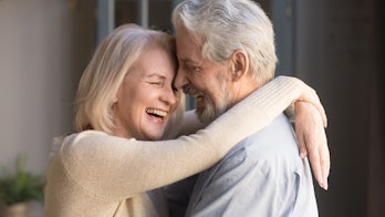 Happy mature couple in love embracing, laughing grey haired husband and wife with closed eyes, horiz...