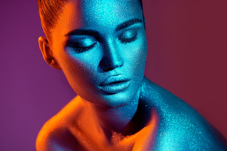Young woman in neon lights with supernatural powers, according to her zodiac sign.