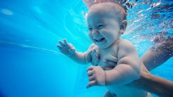 baby swimming underwater, smiling