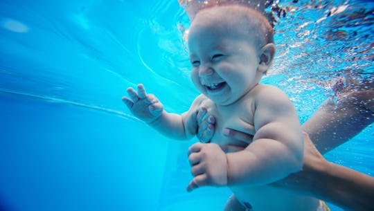 baby swimming underwater, smiling