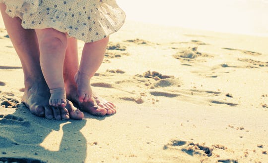 mother and baby feet in the sand on the beach