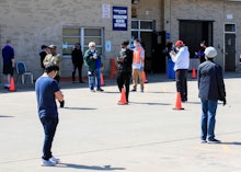 Voters stand apart as they wait in line to cast ballots in the Wisconsin presidential primary electi...