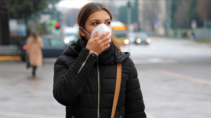 COVID-19 Pandemic Coronavirus Woman in city street wearing face mask protective for spreading of dis...