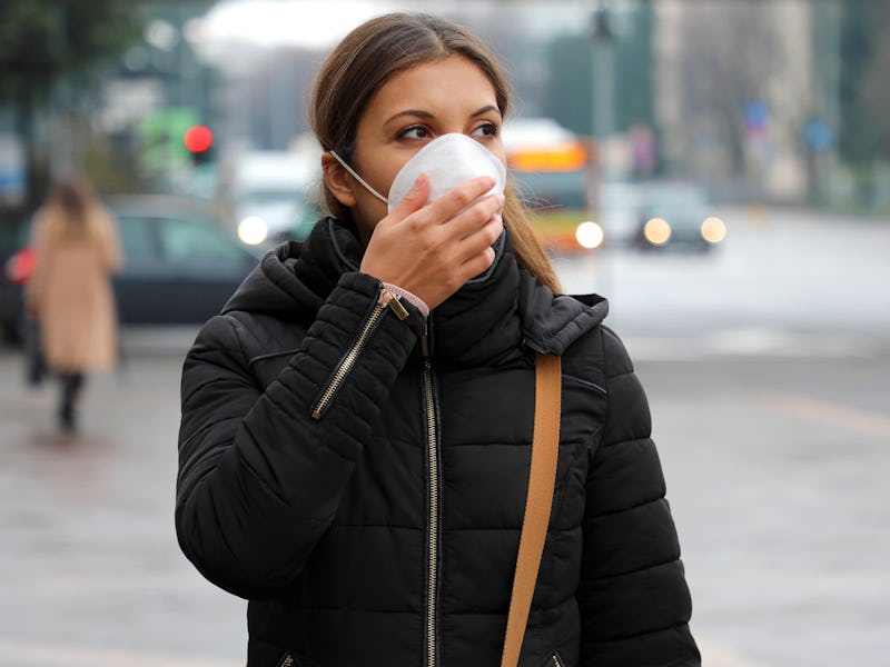COVID-19 Pandemic Coronavirus Woman in city street wearing face mask protective for spreading of dis...
