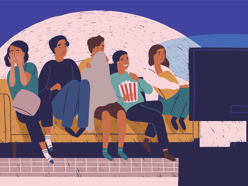 Group of friends sitting on sofa or couch in darkness and watching scary movie. Young girls and boys...