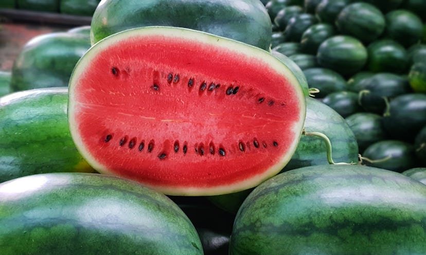 Many big sweet green watermelons and one cut watermelon.Young green watermelon.Watermelon slice.Many...