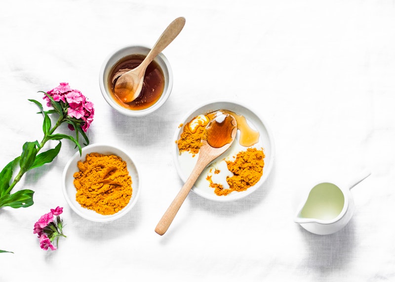 Turmeric, honey, coconut milk face mask. Homemade ingredients beauty products on a light background,...