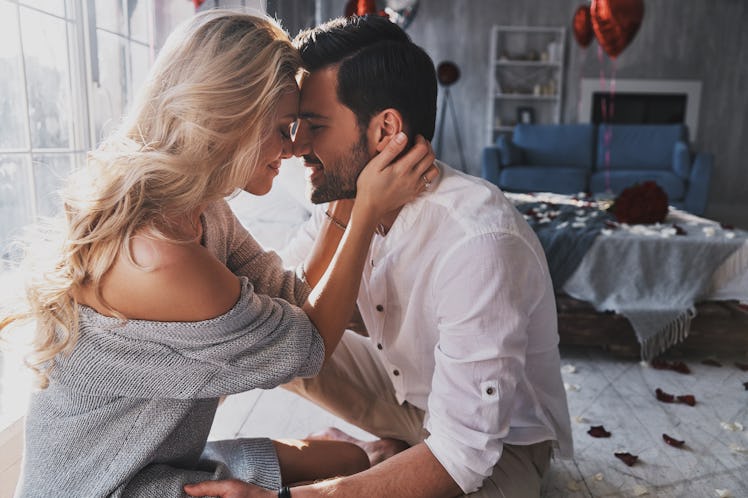 Loving everything about her. Beautiful young couple bonding and smiling while sitting in the bedroom
